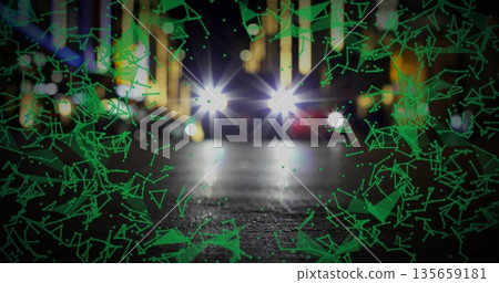 Illuminating vehicle headlights shining across wet road at night, green overlay and blurred lights Illuminating vehicle headlights shining across wet road at night, green overlay and blurred lights 135659181