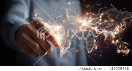 Hand of a person interacts with a glowing digital world map, showcasing interconnected lines and bright points representing global connections and data flow 135659488