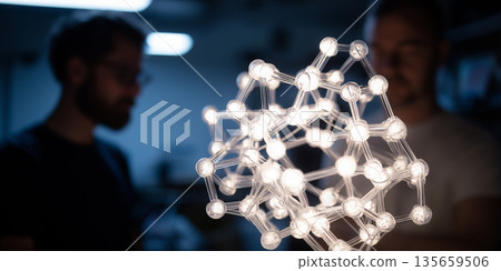 Two male scientists examining a glowing molecular model in a laboratory setting, with blurred background elements indicating research equipment and workspace Two male scientists examining a glowing molecular model in a laboratory setting, with blurred background elements indicating research equipment and workspace 135659506