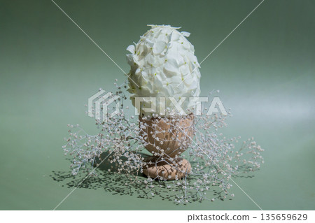 Easter egg made of white lilac spring flowers in pastel green background. Sustainable holiday minimalistic still life composition. Copy space template for invitation greeting card 135659629