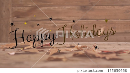 Image of happy holidays text over autumn leaves on wooden background 135659668