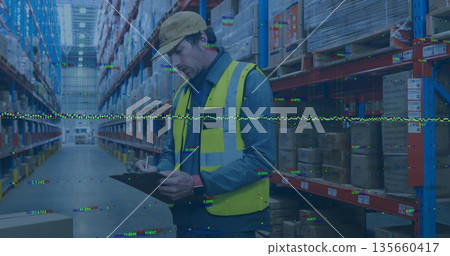 Inspecting worker wearing safety vest and hard hat holding clipboard in warehouse aisle with racks Inspecting worker wearing safety vest and hard hat holding clipboard in warehouse aisle with racks 135660417