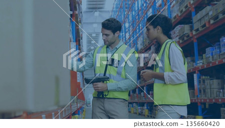 Two workers in neon safety vests scanning boxes on racks in warehouse aisle with handheld scanner Two workers in neon safety vests scanning boxes on racks in warehouse aisle with handheld scanner 135660420