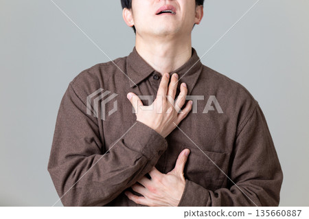 一位中年婦女痛苦地摀著喉嚨 135660887