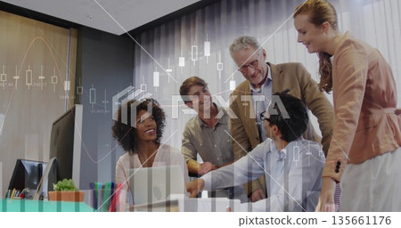 Collaborating team wearing business attire reviewing financial chart at office, with dual monitors Collaborating team wearing business attire reviewing financial chart at office, with dual monitors 135661176