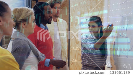 Presenting woman in blue shirt gesturing at panel in office with holographic overlays, copy space Presenting woman in blue shirt gesturing at panel in office with holographic overlays, copy space 135661189