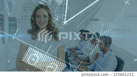 Smiling supervisor wearing white blouse crossing arms in call center with monitors, copy space Smiling supervisor wearing white blouse crossing arms in call center with monitors, copy space 135661252