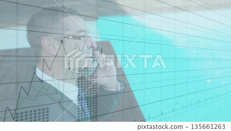 Smiling professional in suit holding smartphone to ear in lobby, with digital charts, copy space 135661263