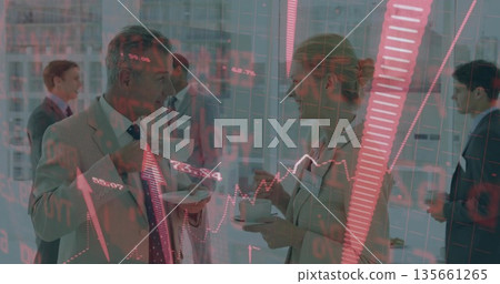 Holding coffee cups and saucers, center executives networking in meeting lounge with stock overlay 135661265