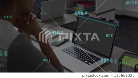 Mature adult African American man focusing on code on laptop at desk, with smartphone, copy space 135661325