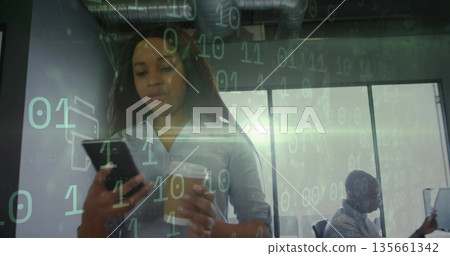 Standing African American woman in office, holding smartphone and coffee cup with binary code Standing African American woman in office, holding smartphone and coffee cup with binary code 135661342