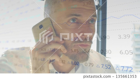 Holding gold smartphone, executive in white shirt watching market data by office window Holding gold smartphone, executive in white shirt watching market data by office window 135661353