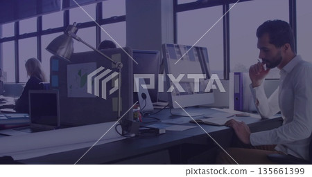 Leaning Middle Eastern man focusing on screen in open plan office with mouse, copy space 135661399