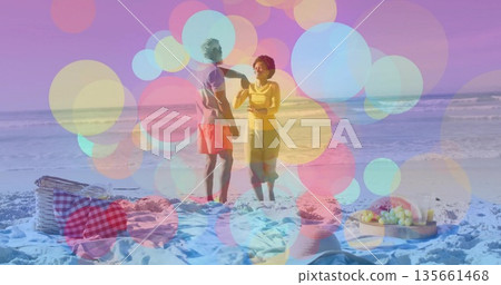 Couple wearing casual clothes talking and holding beverage on beach, with picnic basket, fruit tray Couple wearing casual clothes talking and holding beverage on beach, with picnic basket, fruit tray 135661468