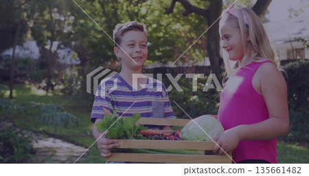 Carrying wooden crate with vegetables, boy in striped T-shirt and girl in pink top in backyard Carrying wooden crate with vegetables, boy in striped T-shirt and girl in pink top in backyard 135661482