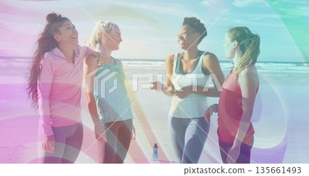Chatting four friends wearing athletic wear on sandy beach near ocean, with reusable water bottle Chatting four friends wearing athletic wear on sandy beach near ocean, with reusable water bottle 135661493