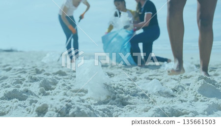 Volunteers collecting plastic debris on beach, with translucent bag fragment using gloves Volunteers collecting plastic debris on beach, with translucent bag fragment using gloves 135661503