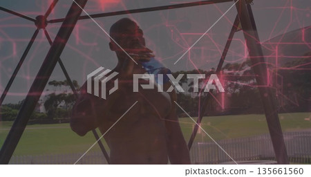 Drinking water shirtless man under metal pavilion at field, with blue bottle, white picket fence Drinking water shirtless man under metal pavilion at field, with blue bottle, white picket fence 135661560