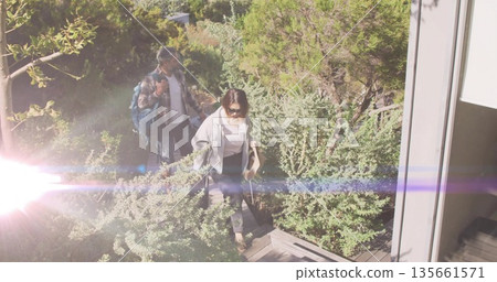 Walking couple ascending wooden pathway at entrance, carrying backpack and tote bag with rolled mat Walking couple ascending wooden pathway at entrance, carrying backpack and tote bag with rolled mat 135661571