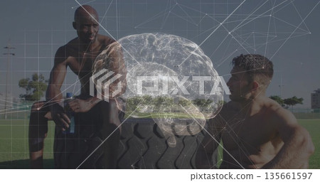 Shirtless partners resting and chatting on field with water bottle, tractor tire and brain hologram 135661597