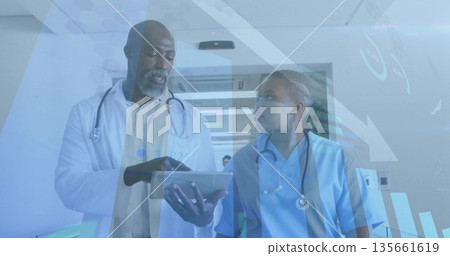 Walking lab coat doctor and scrubs nurse with stethoscopes reviewing tablet in hospital corridor Walking lab coat doctor and scrubs nurse with stethoscopes reviewing tablet in hospital corridor 135661619