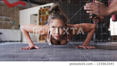 Holding pushup, woman in sports bra and leggings exercising on gym floor, with stopwatch timing Holding pushup, woman in sports bra and leggings exercising on gym floor, with stopwatch timing 135661645