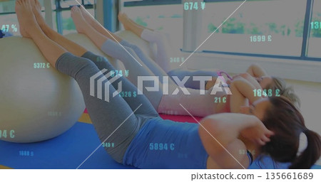 Performing crunches three women in athletic wear on stability balls in studio with windows and mats Performing crunches three women in athletic wear on stability balls in studio with windows and mats 135661689
