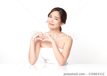 A beautiful young Asian woman with clean, fresh skin against a white background. Skincare, facial treatment, cosmetology, beauty, and spa. An elegant portrait of an Asian woman. 135663312