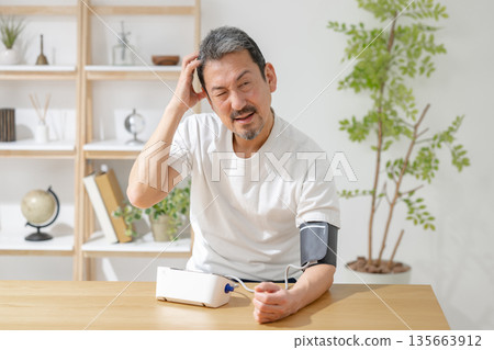中年男子正在測量血壓 中年男子正在測量血壓 135663912