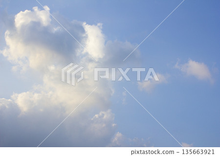 It's a blue sky with atmospheric puffy clouds. It's a blue sky with atmospheric puffy clouds. 135663921