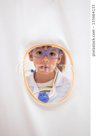 Happy Young Boy Wearing Doctor'S Outfit Inside Tent Happy Young Boy Wearing Doctor'S Outfit Inside Tent 135664135