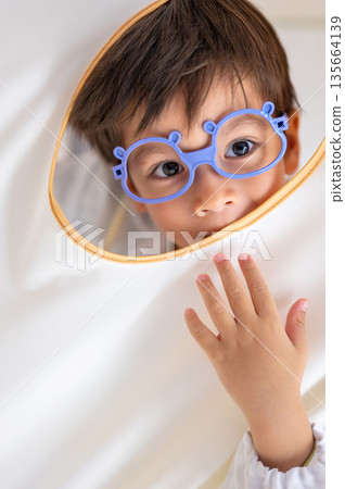 Curious Young Boy Posing Playfully With Medical Outfit 135664139