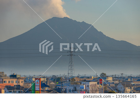 從鹿兒島縣峯良市眺望櫻島,中間聳立著一座高壓輸電塔。 從鹿兒島縣峯良市眺望櫻島,中間聳立著一座高壓輸電塔。 135664165