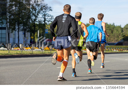 Four male athletes running marathon 135664594