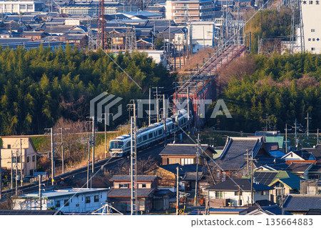 A JR Nara Line train crossing the Kizugawa River bridge. View from Shiroyamadai Castle Ruins Park, Kizugawa City, Kyoto Prefecture. 135664883