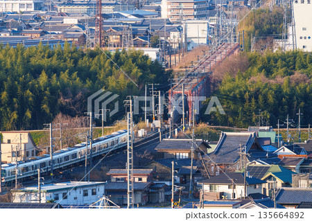 A JR Nara Line train crossing the Kizugawa River bridge. View from Shiroyamadai Castle Ruins Park, Kizugawa City, Kyoto Prefecture. 135664892