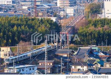 A JR Nara Line train crossing the Kizugawa River bridge. View from Shiroyamadai Castle Ruins Park, Kizugawa City, Kyoto Prefecture. A JR Nara Line train crossing the Kizugawa River bridge. View from Shiroyamadai Castle Ruins Park, Kizugawa City, Kyoto Prefecture. 135664893