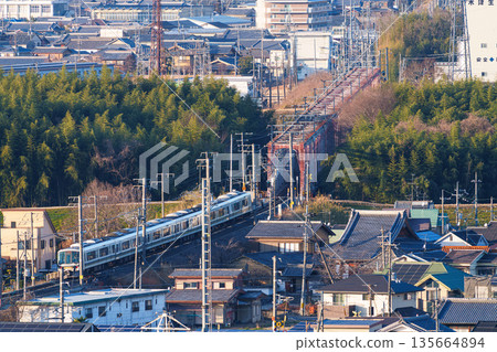 A JR Nara Line train crossing a bridge over the Kizugawa River. View from Shiroyamadai Castle Ruins Park, Kizugawa City, Kyoto Prefecture. A JR Nara Line train crossing a bridge over the Kizugawa River. View from Shiroyamadai Castle Ruins Park, Kizugawa City, Kyoto Prefecture. 135664894