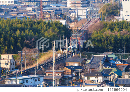 A JR Nara Line train crossing the Kizugawa River bridge. View from Shiroyamadai Castle Ruins Park, Kizugawa City, Kyoto Prefecture. 135664904