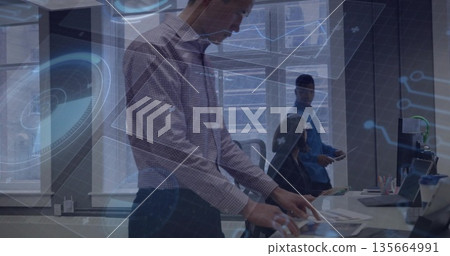 Reviewing mature woman arranging printed documents at white table in office, with laptop smartphone Reviewing mature woman arranging printed documents at white table in office, with laptop smartphone 135664991
