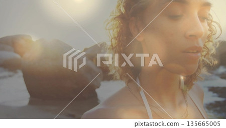 Standing woman gazing at ocean near beach cove, wearing swim top with layered necklaces, copy space Standing woman gazing at ocean near beach cove, wearing swim top with layered necklaces, copy space 135665005