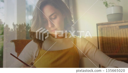 Sketching woman wearing mustard dress at home desk, with sketchbook and forest sunset overlay Sketching woman wearing mustard dress at home desk, with sketchbook and forest sunset overlay 135665020