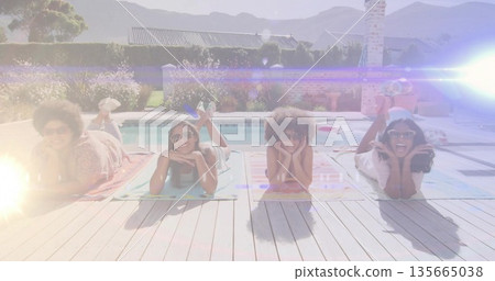 Smiling four women lying on colorful towels on wooden pool deck, with sunglasses and pool float Smiling four women lying on colorful towels on wooden pool deck, with sunglasses and pool float 135665038