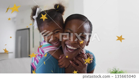 Mother and daughter sharing piggyback ride and laughing joyfully in modern home, with star graphics Mother and daughter sharing piggyback ride and laughing joyfully in modern home, with star graphics 135665040