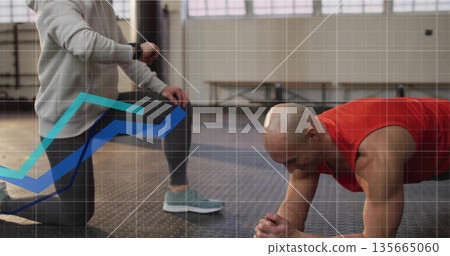 Male client holding plank in gym on mat, trainer checking smartwatch, copy space Male client holding plank in gym on mat, trainer checking smartwatch, copy space 135665060