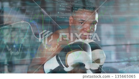 Holding stance boxer displaying market data overlay in gym ring ropes, with white and black gloves 135665065