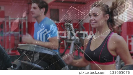 Running woman in sportswear on treadmill at gym, with digital console and weight racks, copy space 135665076