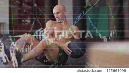 Shirtless male performing torso rotation in gym, with medicine ball and stock chart overlay Shirtless male performing torso rotation in gym, with medicine ball and stock chart overlay 135665096