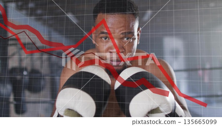Showing shirtless boxer holding gloves in boxing gym with bags, ropes and red graph grid overlay Showing shirtless boxer holding gloves in boxing gym with bags, ropes and red graph grid overlay 135665099