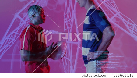 Facing off two athletes holding rugby ball in pink studio, with wireframe hexagon code overlays Facing off two athletes holding rugby ball in pink studio, with wireframe hexagon code overlays 135665115